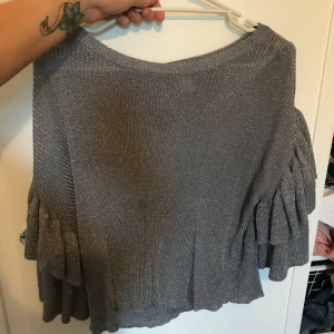 Glittrig topp med volanger  - Oanvänd topp i storlek XS, stor i storleken så passar även en S och M 