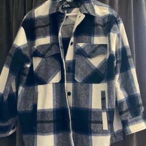 Rutig jacka från Zara - Säljer denna jacka från Zara. Använd en gång så den är i helt perfekt skick. Storlek XS men stor så den passar vem som helst. Nypris ca 500kr, säljer den för 150kr eller lämpligt bud. Frakt tillkommer.😊