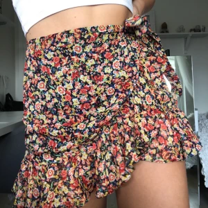 Blommig volangkjol - Blommig volangkjol med knytning på sidan från Urban outfitters