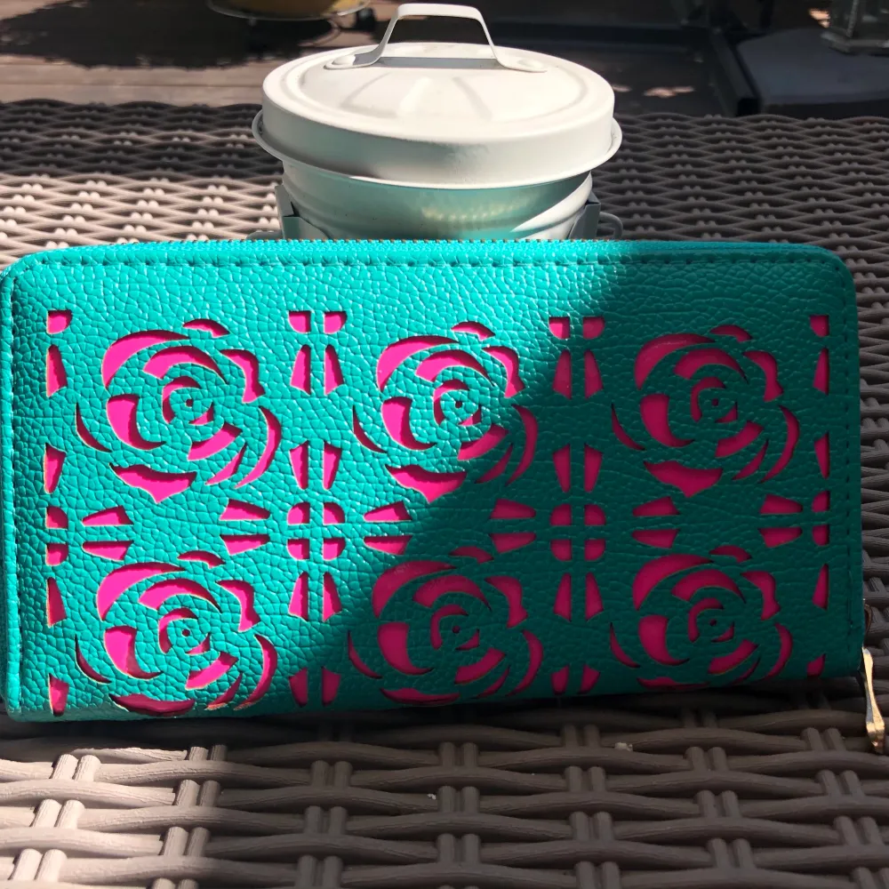 En superfin plånbok i jättebra skick, med guld detaljer och är i en turkos-aktig färg med neon rosa detaljer. Använd ett fåtal gånger. Frakt tillkommer 🥰. Väskor.