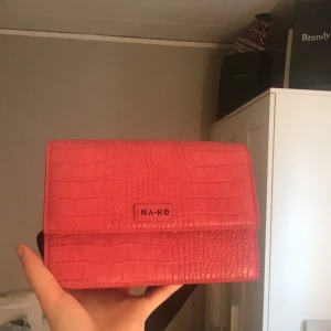 NA-KD midjeväska - NA-KD midjeväska som är helt oanvänd. Otroligt cool men säljer iväg till någon lycklig då den tyvärr bara stått utan att blivit använd tyvärr. Storleken på väskan är 19x13 cm vilket gör att den är perfekt till utekvällen. Sänkt pris från 100 till 80. Frakt tillkommer.