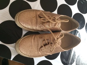  - Snygga glittriga skor i guld från märker Forever 21. Köpta i London får två år sedan. Skorna är i väldigt gott skick. 
Frakt tillkommer. 