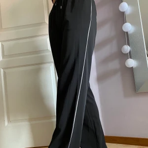 Svarta tygbyxor med vit detalj - Bekväma byxor med knytning i midjan från Anna Field! Storlek 36🖤