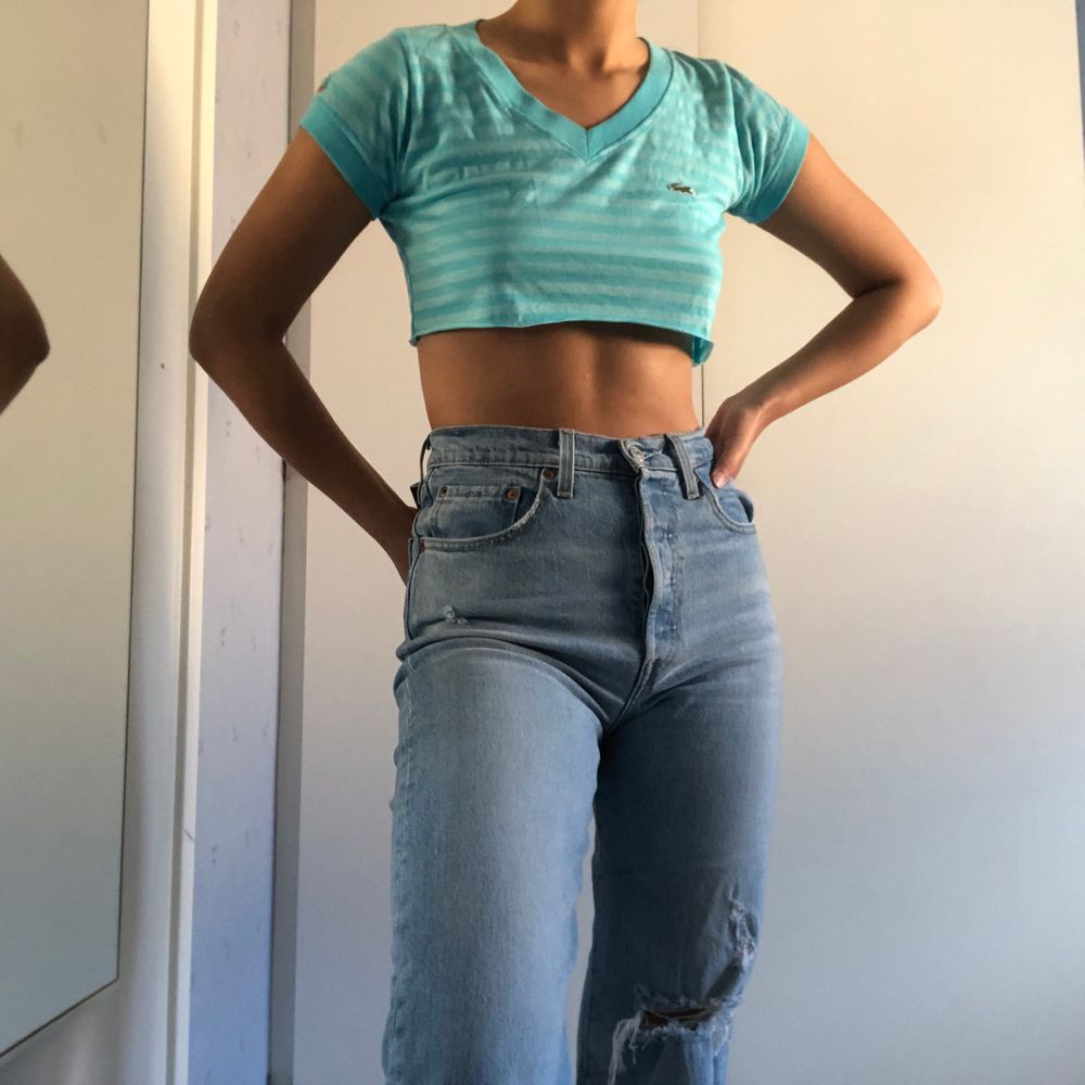 En tshirt från Lacoste avklippt till en snygg croptop. Croptopen är lätt att stylea och passar till allt. Toppar.