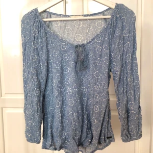 Ljusblå blus strl. S - Ljusblå blus med vackert mönster. Faller snyggt. Från märkesbutiker i Sydafrika. Passar strl S