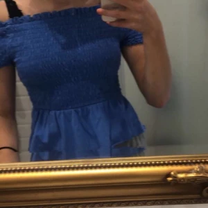 Blå off shoulder topp - Superfin off shoulder topp från Gina Tricot med volanger ner till. Toppen är i strl XS. Köparen står för frakten