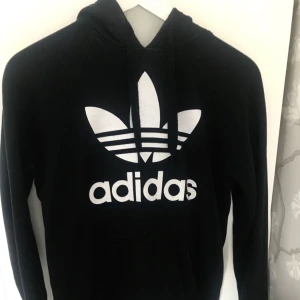  - Svart klassisk hoodie från Adidas. Använd men i bra skick. Köparen står för frakt.