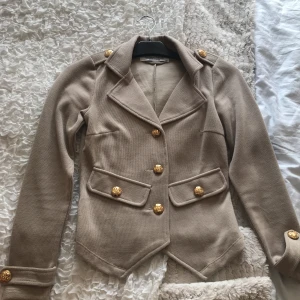  - Oanvänd kavaj från bubbleroom av märket chiara forthi milano. Beige med gulddetaljer. 