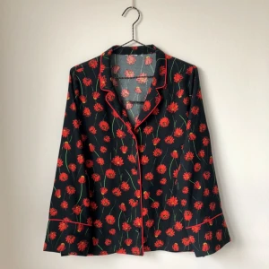  - Topp i pyjamas-modell. Mörkblå med röda blommor. Säljer även matchande byxor. 