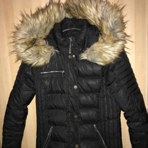  - Fin jacka från Chelsea. Fuskpäls. I nytt skick, men dragkedjan längst upp kan vara svår att dra up, men inget som stör då det finns knappar. Passar storlekarna 38-40. Nypris: 1000kr