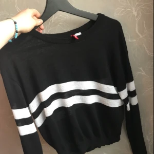  - Halvt genomskinlig topp, svart långärmad med vita ränder. Hyfsat kort, skulle nog säga att det är en typ som en crop-top. 