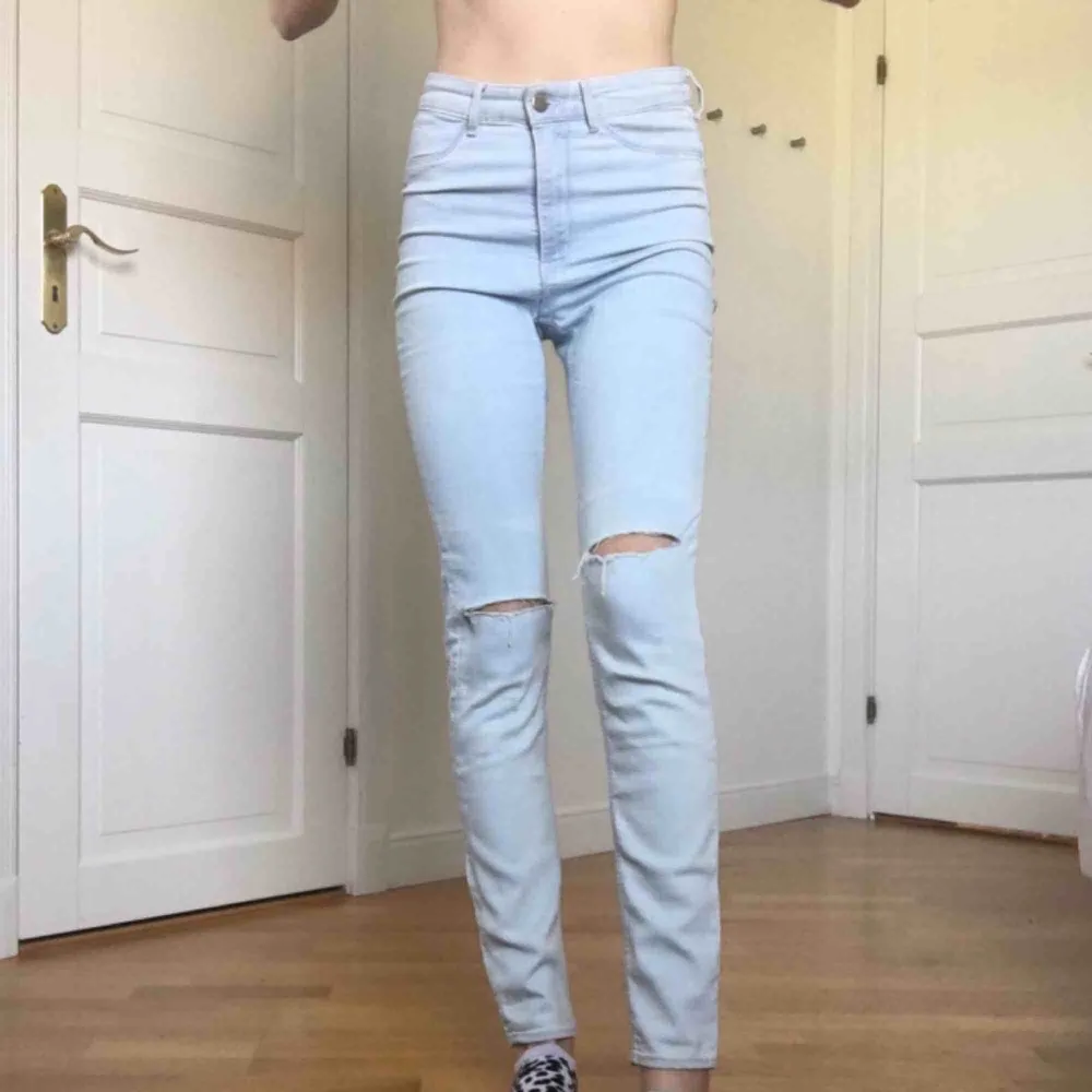 Högmidjade, jusblåa oanvända jeans med hål på knäna. Jag vet själv hur svårt det är att köpa jeans online så du får bestämma priset men lägsta/frakten är 55kr. Jag är 175cm lång och har 34 i jeans så därför sitter de lite loose. Jeans & Byxor.