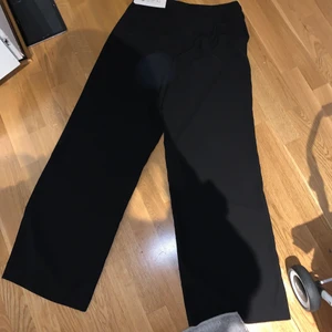 Kostymbyxor utsvängda 44 OANVÄNDA - Utsvängda kostymbyxor med dold dragkedja i midjan. Storlek 44. Aldrig använda 