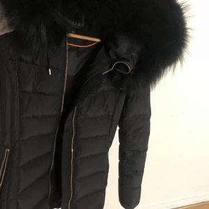 Hollies tribeca strl 32 - Hollies tribeca jacka i strl 32 med äkta päls i svart samt en ljus päls (också äkta) till luvan. Sparsamt använd. köpt för ca 5000 kr säljes för 1500