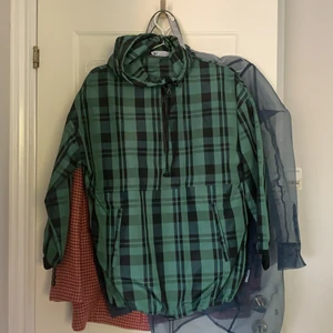 Rutig parkas  - Grön rutig parkas i tunnt material med luva och en stor ficka. Lite kortare i ärmarna. Köpt på Zara. Endast använd en gång, därav som ny. 