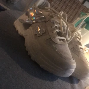 Snygga chunky sneakers - Helt nya vita chunky sneakers med holo detaljer i strl 38, aldrig använda endast prövade! Säljer pga att jag beställde i fel storlek. Säljer för 200 kr med gratis frakt!