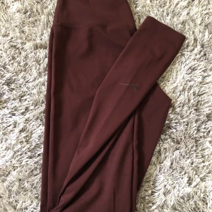 tights från nike  - ett par mörklila/ bruna tights från Nike. högmidjade och materialet sitter tight men samtidigt väldigt bekväma. kan mötas upp i växjö eller så står köparen för frakten.😇