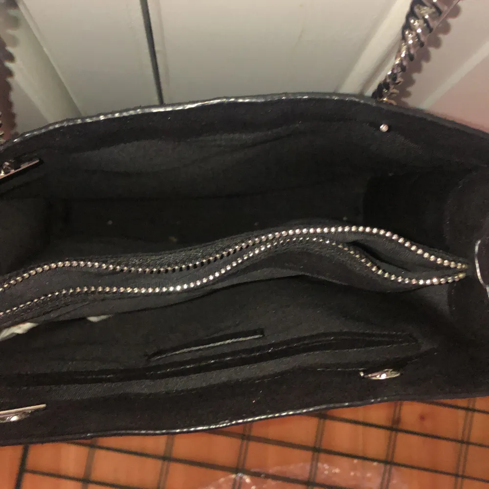 En svart mocka väska från Zara (vet ej om det är äkta) rymmer mycket, har tre fack. Använd ca 5 ggr. Nypris 600. Väskor.