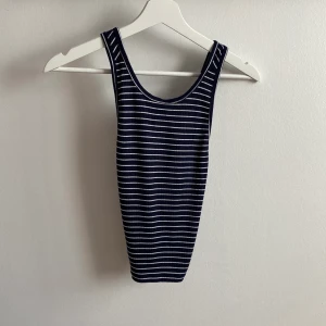 hollister linne medium - randigt mörkblått linne från hollister i strl. M! banden överlappar varandra på ryggen, väldigt stretchigt material, skulle säga passar S-L