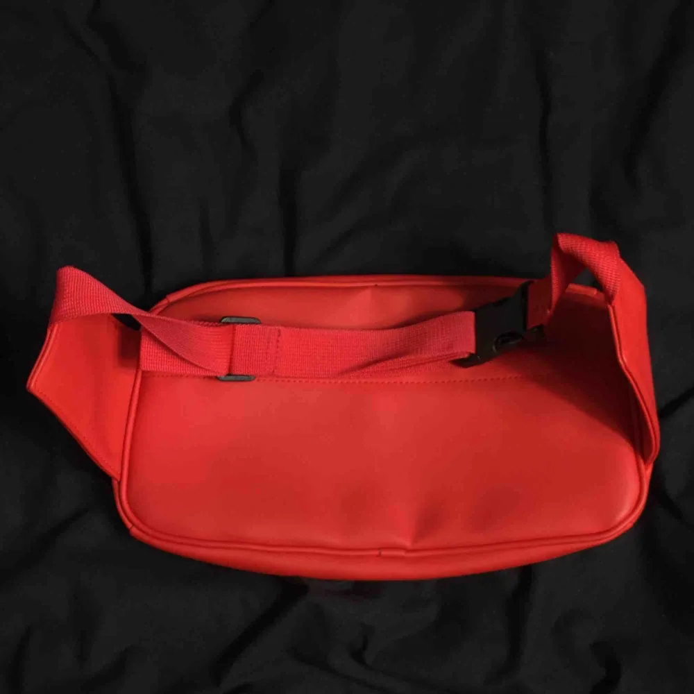 Röd Midjeväska från hm men's. Använd ca. 10 gånger, helt ny kvalité. Har flera fickor både utanför och innanför, mycket utrymme. Frakt är + 30kr. Väskor.