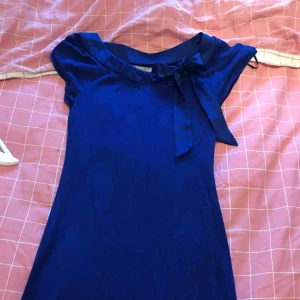  - En mörkblå klänning med rosett i XS , passande till julen! Använd en jul, så det är i nyskick !
