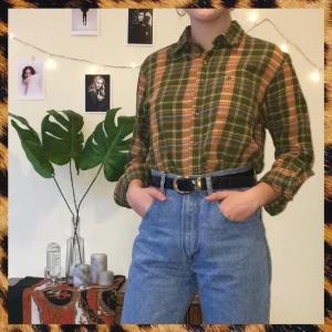  - Assnygg flannelskjorta köpt på second hand! Står ingen exakt storlek i den, men på mig som normalt sätt har xs/s så har den en lite oversized passform. Jättefin instoppad i ett par mom jeans med ett snyggt bälte som på bilden, eller med en jeanskjol :) I bra skick!