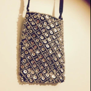  - Halsväska i satin med blingbling på i form av paljetter och silverpärlor. Aldrig använd utan ba blivit hängandes tyvärr. Säljes pga går på csn. 