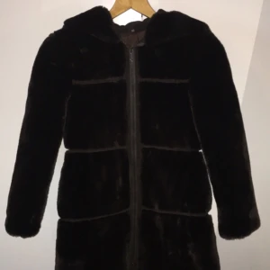  - Mörkbrun 70-tals kappa i storlek 146 (barnstorlek. Jag som är XS-S kan knäppa den precis. Upphämtning i Göteborg. Luva och fickor är rätt tighta. Baksidan av ärmarna är släta. 