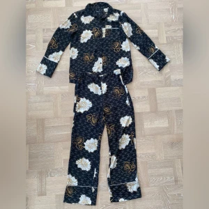 Mönstrat set - Jättefint mönstrat set i ”pyjamasmodell” (satinmaterial). Strl 38 på både skjortan och byxorna. 200kr för båda delarna! Frakt tillkommer