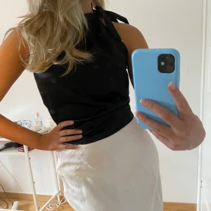 Linne i silkesmaterial - Ett svart linne som man knyter vid halsen i ett slags silkes material! Är i jättebra skick pga av endast använd några få ggr! Säker för 100+frakt!