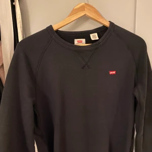 svart levis sweatshirt - en svart levis sweatshirt som inte används längre, den är i mansstorlek 