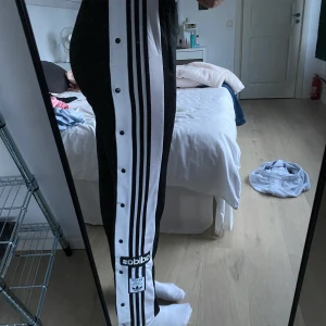 Adidas byxor med knappar storlek M - Jättesköna byxor från adidas med knappar på sidorna, använda få gånger! Köpte för 800kr. Köparen står för frakt