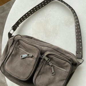 Noella väska - Grå noella väska, väldigt rymlig med många fack, bra skick, inga skador, ett till band som ni ser på sista bilden tillkommer (+dustbag)