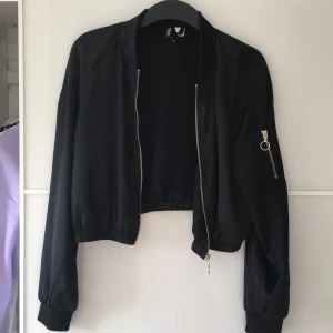 Snygg kofta/jacka  - Ett väldigt fint plagg som du både kan använda som en kofta eller tunnare jacka! Den är svart och lite glansig så funkar både i skolan eller till fest och andra aktiviteter! Storlek 38 men ganska lite i storleken, mer som 36! 