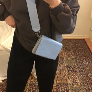 Carin Wester väska  - Ljusblå Carin Wester väska som jag inte använder längre. Två fläckar på framsidan och en liten fläck på baksidan som inte syns. Extra axelband ingår. Budgivningen i kommentarerna. Frakt ingår!