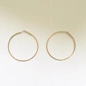 Hoopearings - Guldiga örhängen (INTE äkta guld) från new yorker. Bara använda 1 gång. Diameter: ca 7 cm. Omkrets: ca 22 cm (ganska stora). Kan mötas upp i Kristianstad och Hässleholm annars kostar frakt 10 kr. 