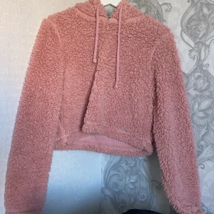 Fluffig och mysig hoddie från Hollister. Storlek S - Detta plagg är köpt i Hollisterbutiken för ungefär 1 år sedan. Den är i toppskick då jag använt den max 2 gånger. Den är mysig, har långa ärmar och är ner till höfterna på mig (167 cm). Köpte den för 300-400kr ungefär. 