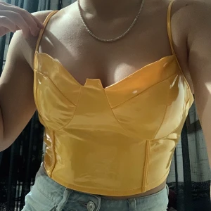 Lackad topp  - Skitsnygg topp i lackat material, stängs med dragkedja i ryggen. Använd en gång så är i bra skick 🌻