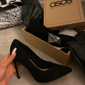 Svart höga pumps st.38 - Säljer dessa fina svarta pumps köpta från Asos st.38 passar även 37,5, klacken är 11cm. Använda endast några timmar. Säljer pga lite för små på mig