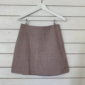 Smårutig kjol, Monki - Kjol som knäpps i bak med dragkedja. Använd men i fint skick. Passar mig som vanligtvis har storlek S men kan vara svår att få över höfterna om man har lite bredare höfter. Frakt tillkommer (42kr). 