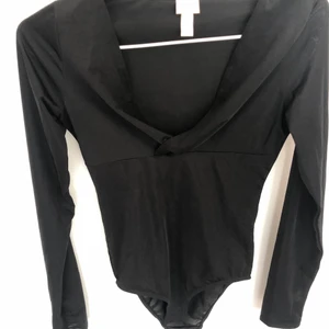 Svart body med urringning - Snygg svart body med ganska djup urringning. Från hm och har ett lite glansigt material. Sitter supersnyggt men har tyvärr blivit för liten för mig. 