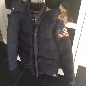  - Marinblå vinterjacka från Ralph Lauren, köpt i Mood gallerian i Stockholm. Sällan använd så jättefint skick. Pälsen är i imitation.
Storlek S, unisex modell.
Ordinarie pris: 2800
Mitt pris: 1000