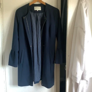 Jacka/kappa från vila  - Säljer denna jättefina blåa jackan/kappan från vila, i storlek S. Jackan har fickor i sidorna och små puffar längst ner i ärmarna.  Den är använd ett förtal gånger och är i ett jättefint skick. Köpt för 500kr säljer för 300kr, billigare vid snabbaffär! 