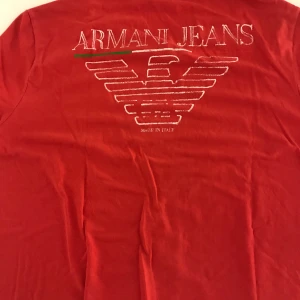 Armani Jeans T-shirt strl M - Röd Armani t-shirt köpt i Prag inne på självaste Armani Jeans butiken! Galet kap av dig som köper den
