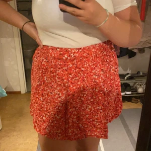 Kjol  - Röd blommig kjol från NewYorker passar som M/L 