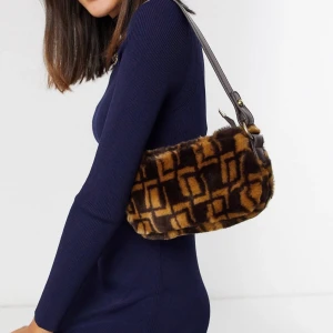 Fakefur axelväska från Asos. - Snygg och trendig axelväska från Asos med guld detaljer. 150 kr inkluderad frakt. 