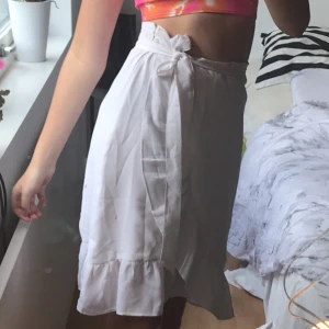 Vit kjol med omlott - Vit kjol köpt på Ullared, använd en gång. Frakt ingår inte i priset.