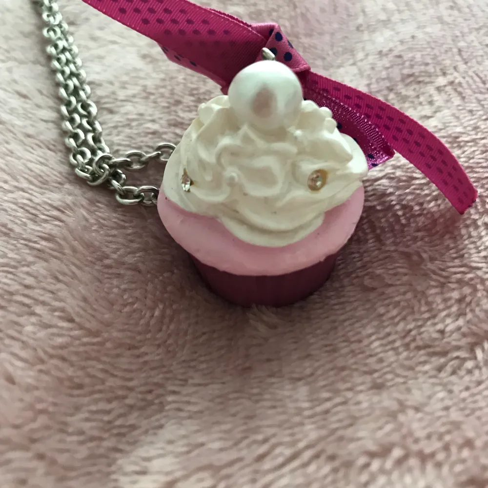 Ett långt halsband med en stor rosa cupcake på 😍 Cupcaken är ca 5-6 cm hög och har en rosa rosett kring sig 💕💗 Supersöt, fint skick, väldigt Lolita ✨ . Accessoarer.