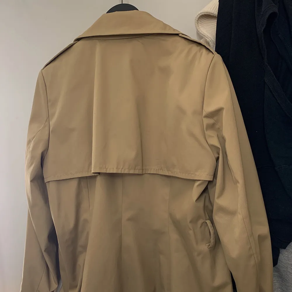 Säljer denna oanvända beiga trenchcoat/kappa ifrån H&M. Lapparna sitter fortfarande kvar och extraknappar finns. Den har lite axelvaddering. Storleken är i 44 men den passa på mig som brukar ha 32-34 vanligtvis. Är 164 cm lång. Bältet och ett ärmbälte saknas, men enligt mig så märks det ej! Kan mötas upp vid Stadions tunnelbana eller så kan jag kicka den!🤗 skriv om ni vill ha fler bilder.. Jackor.