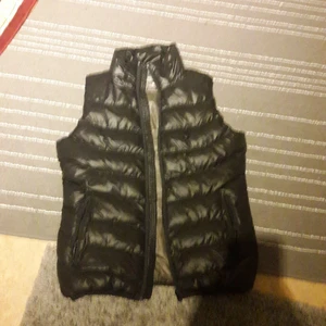 Dun väst - En svart dun väst me två fickor på sidan och en dragkedja ,ny pris 400 kr